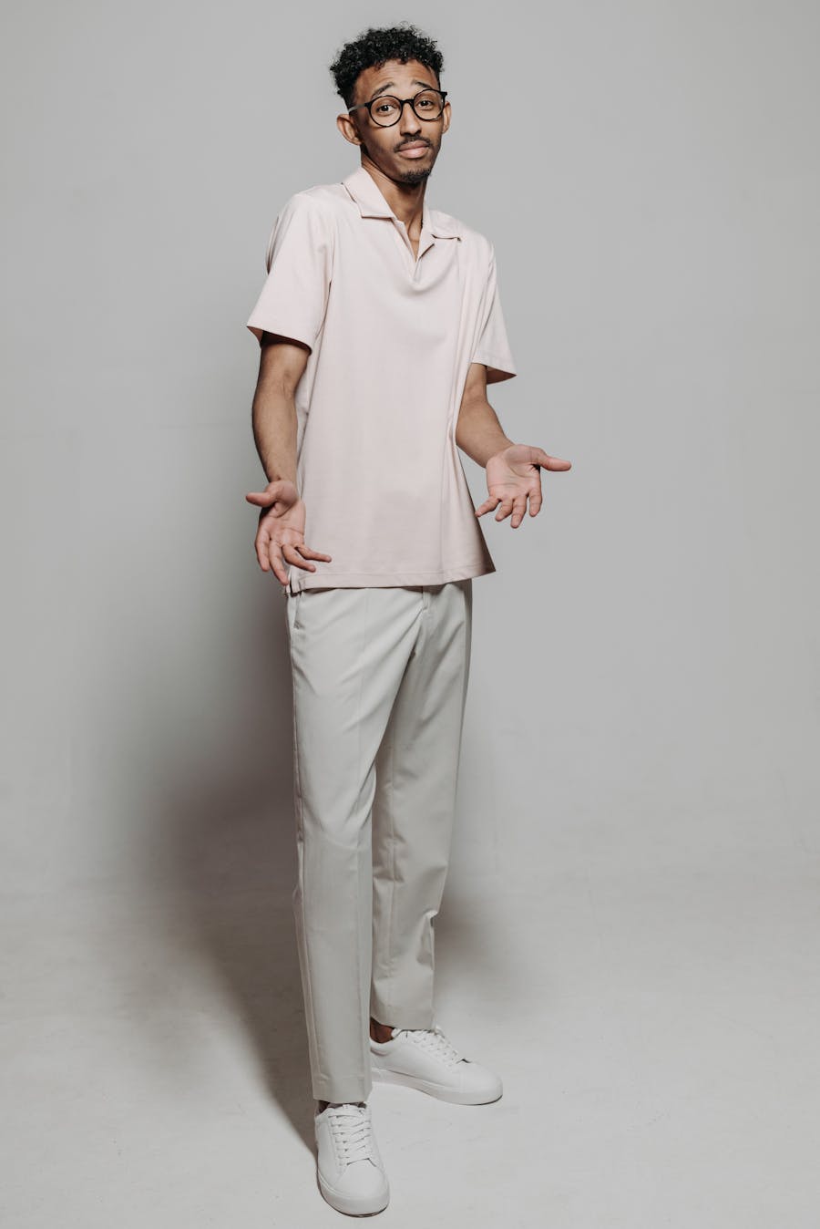 Real photo of a person standing front view, plain background, neutral pose